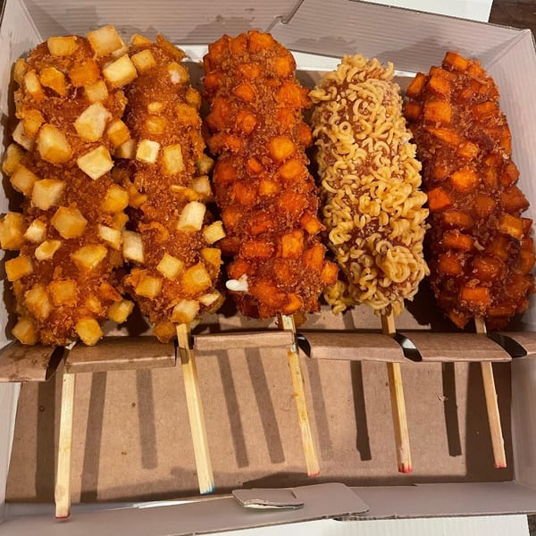 Four Chung Chun Rice Dogs, two with potato cubes, one with ramen, and one with sweet potato.