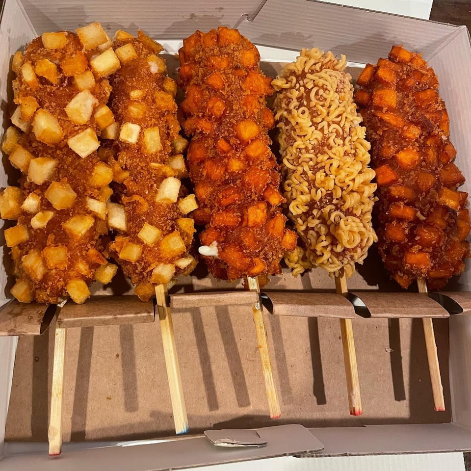 Four Chung Chun Rice Dogs, two with potato cubes, one with ramen, and one with sweet potato.